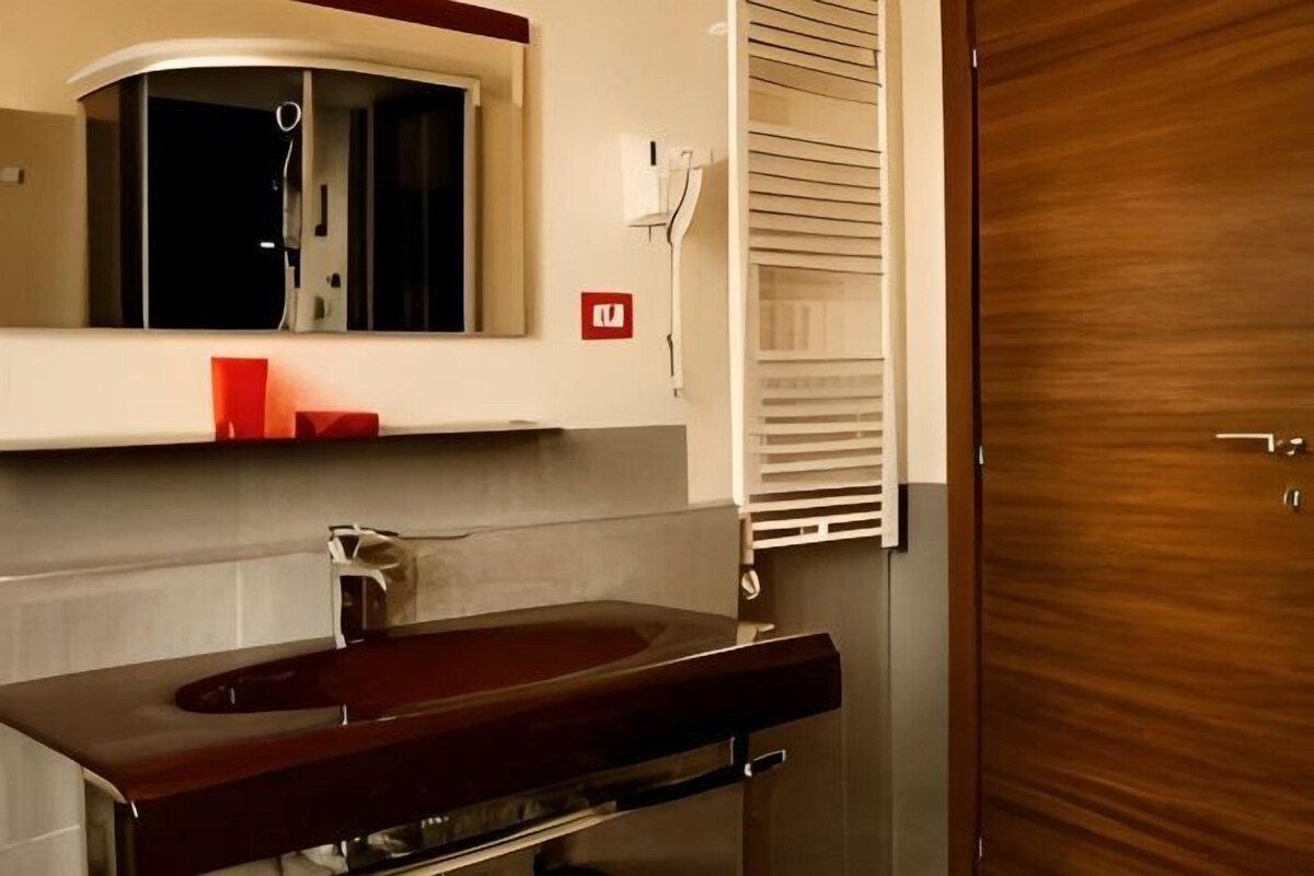 A bathroom with a sink, mirror, and towel rack.