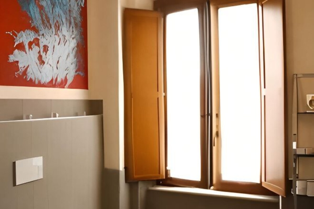 Um banheiro com janela, porta-toalhas e interruptor de luz na parede.