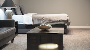 Ein Schlafzimmer mit Bett, Nachttisch, Lampe und Couchtisch.