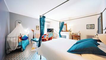 Een slaapkamer met een bed, nachtkastje, stoel, bureau en een raam met gordijnen.