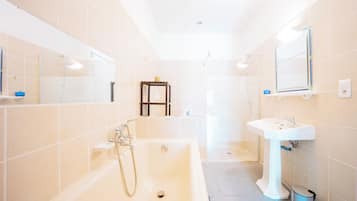 A modern bathroom with a bathtub, a sink, and a shower.