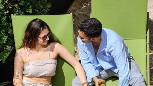 Two people reclining on green lounge chairs with towels and a tray of fruits. - Fiori 41 (Tel Aviv)