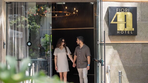 The entrance of Fiori 40 Hotel with a glass door, a signboard, and a modern interior visible through the door. - Fiori 41 (Tel Aviv)
