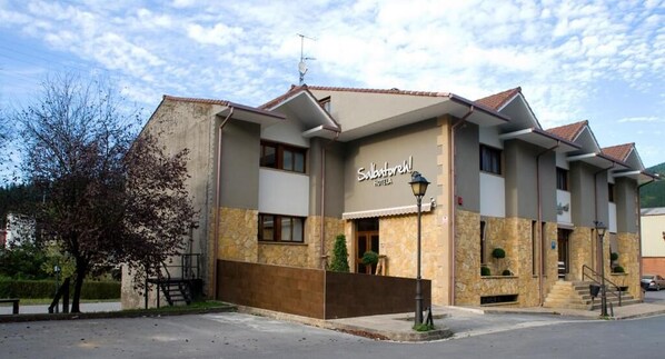 Ein Hotel mit einer steinernen Fassade, mehreren Balkonen und einem Schild mit der Aufschrift 'Salvatore Hotel'.