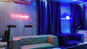 Eine VIP-Lounge mit Leuchtzeichen, Ledersofas und gedämpfter Beleuchtung.