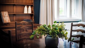 A wooden dining table with a potted plant, a wooden chair, and a bookshelf in the background. - 2 The Quadrant Luxury Apartments Hoylake (Hoylake)