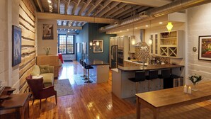 A modern kitchen with a central island, bar stools, and a dining table. - Luxury Loft in the Rochester Public Market! (Rochester)