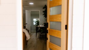 A doorway leading into a room with a wooden door and a small step.
