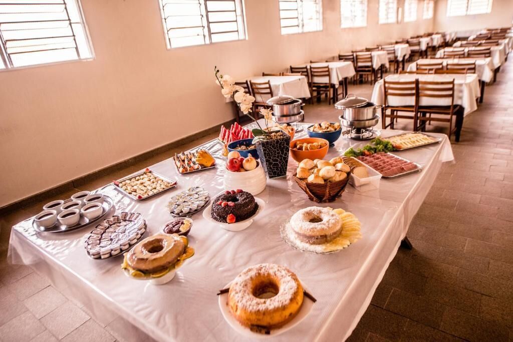 Una mesa de buffet con diversos alimentos y una olla grande en el centro.