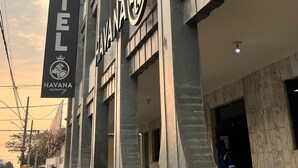 A hotel with a modern architectural design, featuring a prominent sign with the name "HAVANA economy" and a logo. The building has a series of balconies and large windows. - Havana Economy (Uberaba)