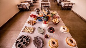 A buffet table with various food items and dishes. - Havana Economy (Uberaba)