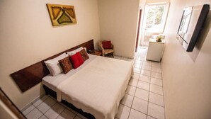 A bedroom with a bed, a chair, and a small table. - Havana Economy (Uberaba)