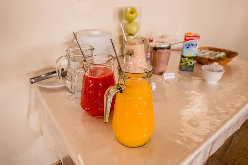 A beverage station with various drinks and a milk carton on a table.