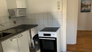 Ett kök med en spis, diskho och skåp.
