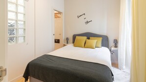A bedroom with a bed, a nightstand, a lamp, a window, and a door. - Cozy apartment 5 minutes walk from the Colosseum (Roma)