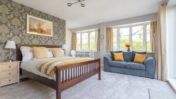 A bedroom with a wooden bed, a sofa, and a desk.