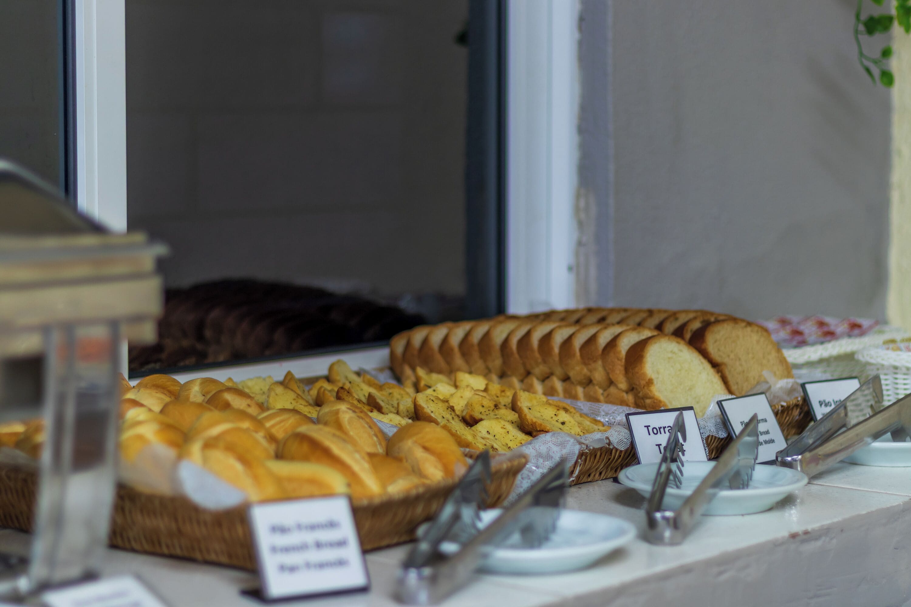 A buffet with various breads and pastries.