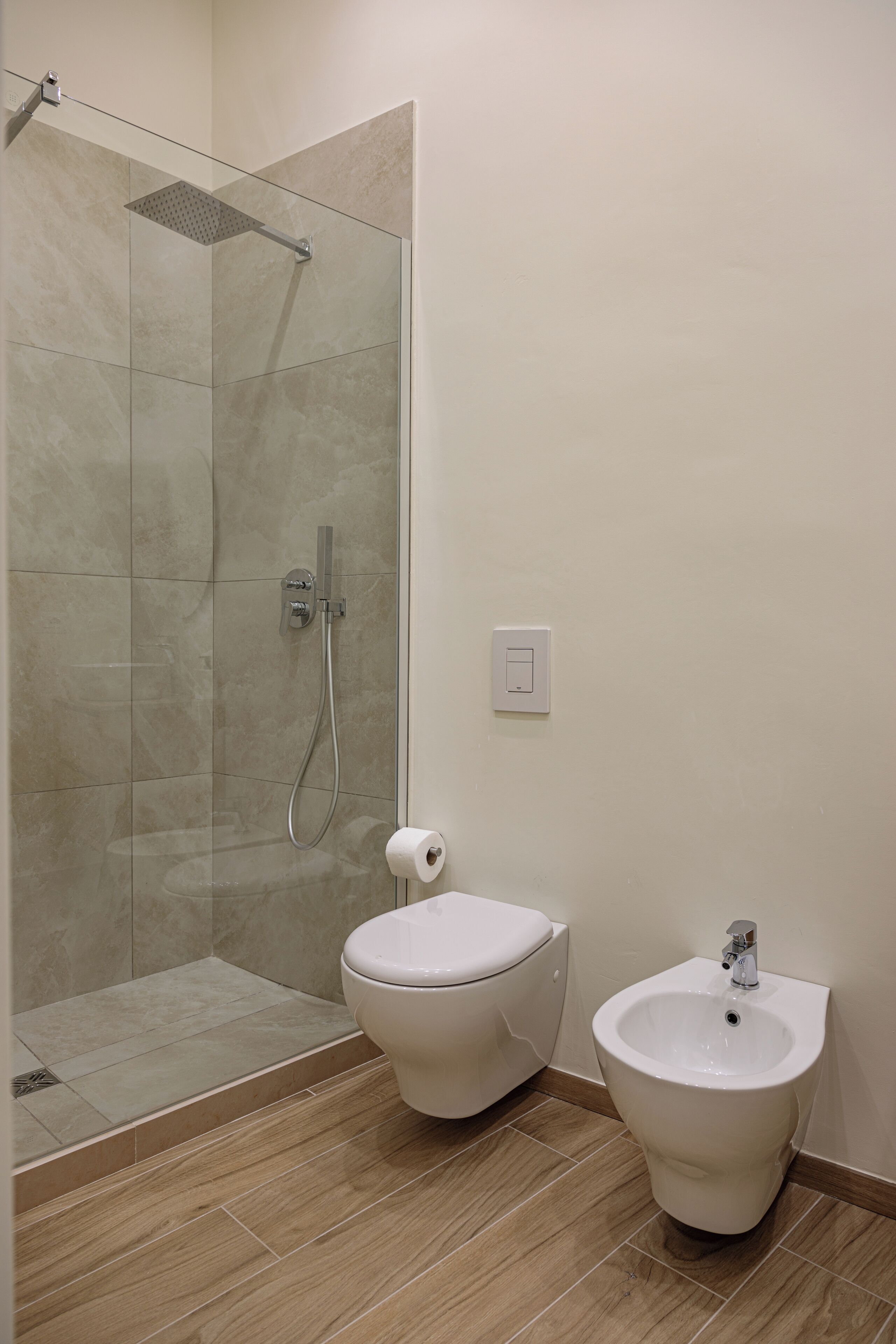 Ein Badezimmer mit Dusche, Toilette und Bidet.