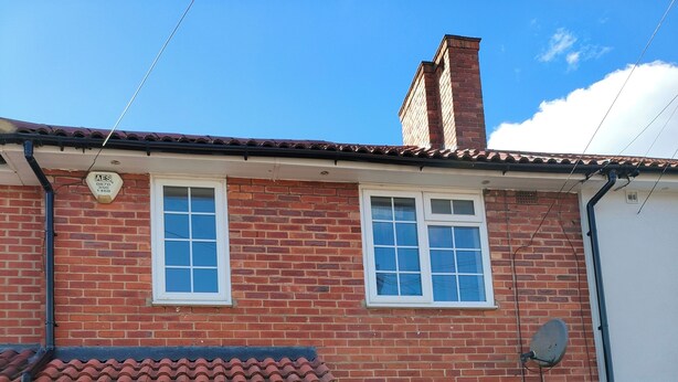 A two-story brick house with a dark front door, two windows, and a satellite dish. - South London 3 Bedroom House (Carshalton)
