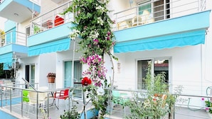 A building with multiple balconies, outdoor seating, and potted plants. - Elfida Apart Palamutbükü (Datça)