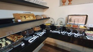 A buffet with various food items and serving utensils. - Nordeste Palace Hotel - Glória/SE (Nossa Senhora Da Gloria)