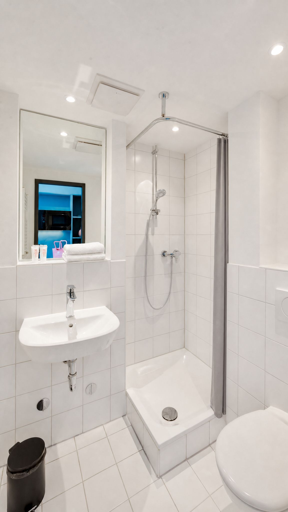 Un baño moderno con ducha, lavabo e inodoro.