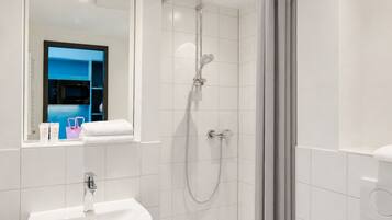 A modern bathroom with a shower, sink, and toilet.