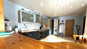 Una cocina moderna con encimera de madera, electrodomésticos integrados y salpicadero de azulejos.
