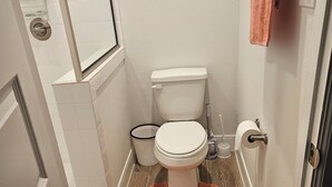 A bathroom with a toilet, a shower, and a small window. - Luxury studio with AC, WiFi in wonderful Houston (Houston)