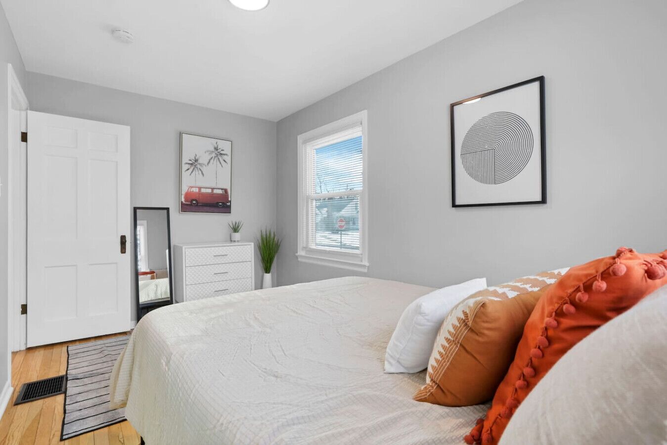 Un dormitorio con cama, cómoda, ventana y puerta.