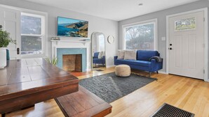 Un salon moderne avec une cheminée, un canapé bleu et une table à manger.