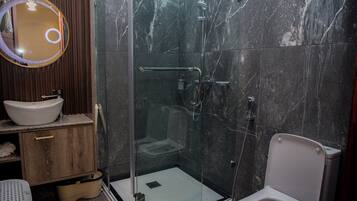 Une salle de bain moderne avec une douche à parois de verre, un lavabo blanc et un meuble-lavabo en bois.