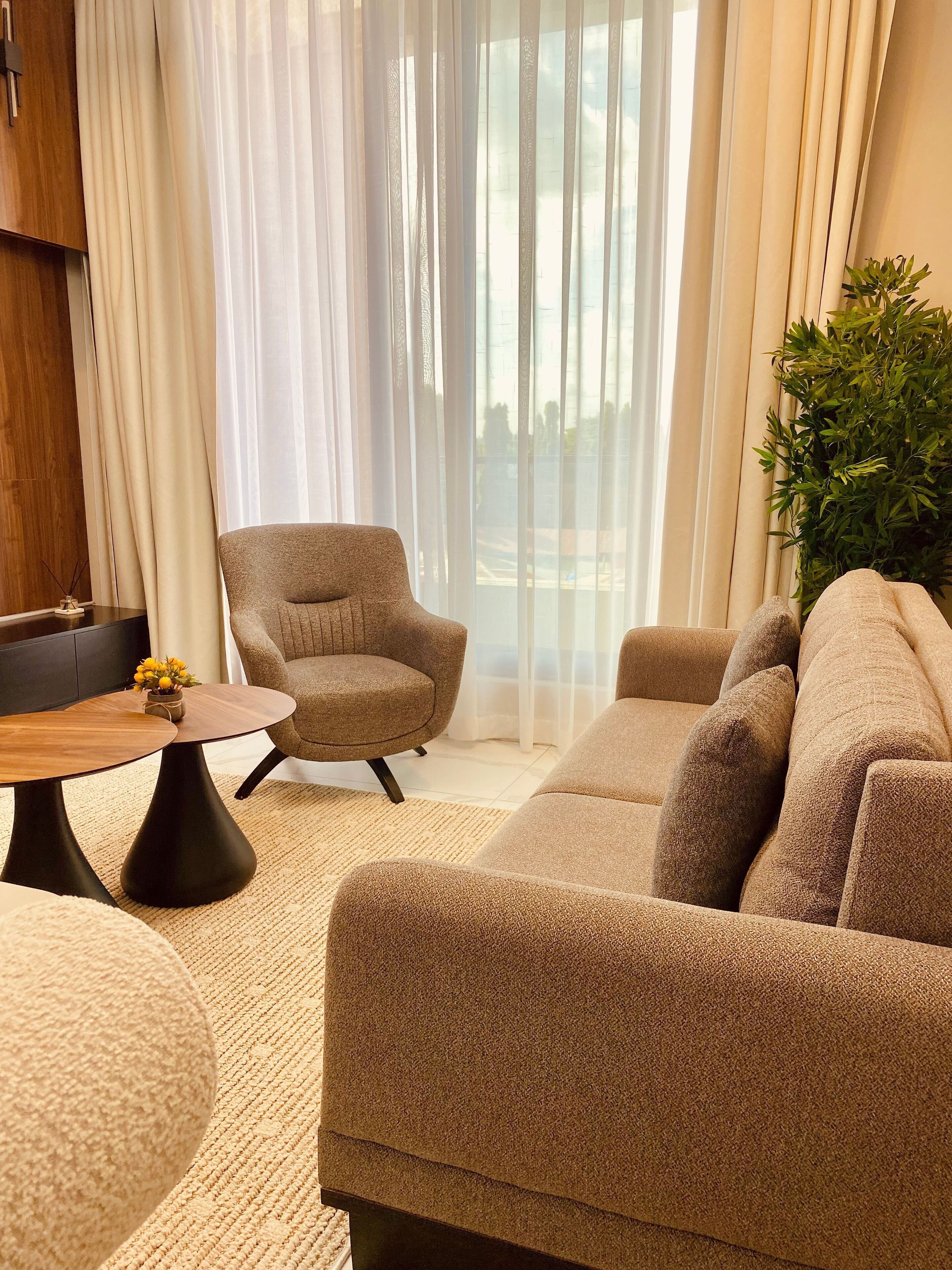 Ein modernes Wohnzimmer mit einer Couch, einem Sessel und einem Couchtisch.