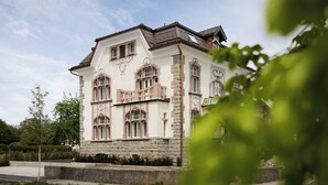 Un edificio grande e histórico con múltiples ventanas y base de piedra.