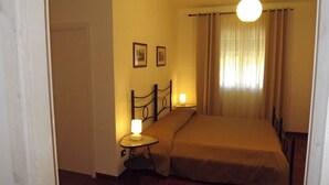A small, cozy bedroom with a single bed, a bedside table with a lamp, and a wall-mounted picture. - Villa Apollonia B&B  (Monopoli)