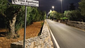 A nighttime street view with a sign for Villa Apollonia Bed & Breakfast pointing left. - Villa Apollonia B&B  (Monopoli)