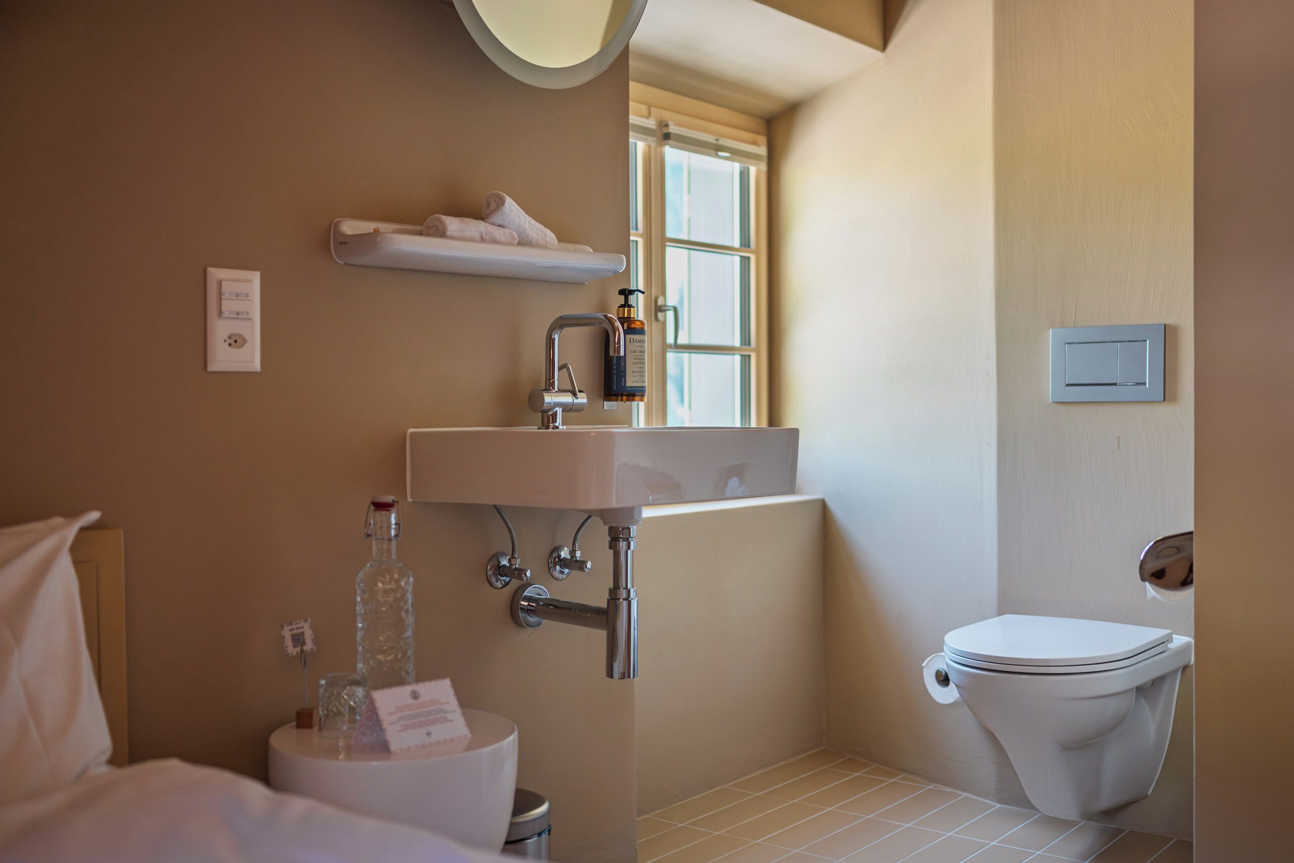 Ein Badezimmer mit Toilette, Waschbecken und Fenster.
