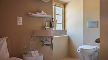Ein Badezimmer mit Toilette, Waschbecken und Fenster.