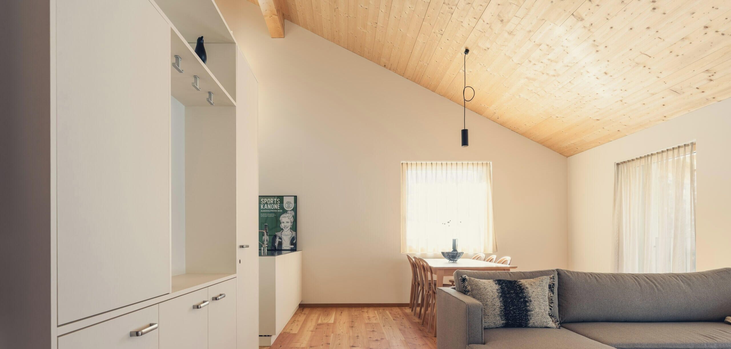 A modern interior with a dining area, a sofa, and a kitchen.