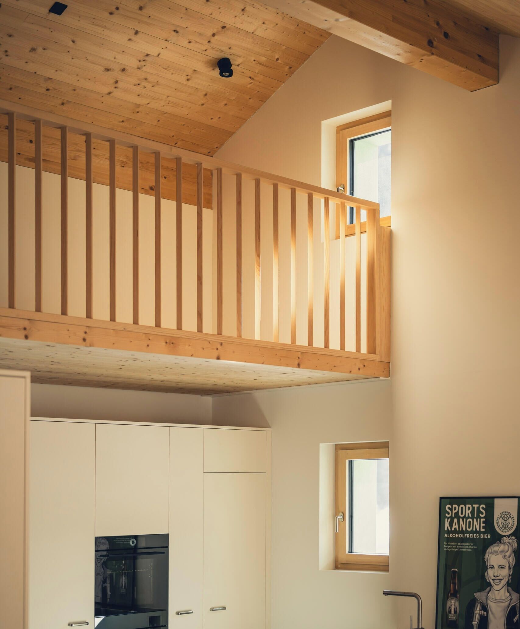 Un cuarto estilo loft con techo de madera y una ventana pequeña.