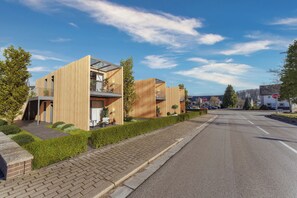 Un edificio residenziale moderno con tetto piatto, ampie finestre e vialetto in pavé.