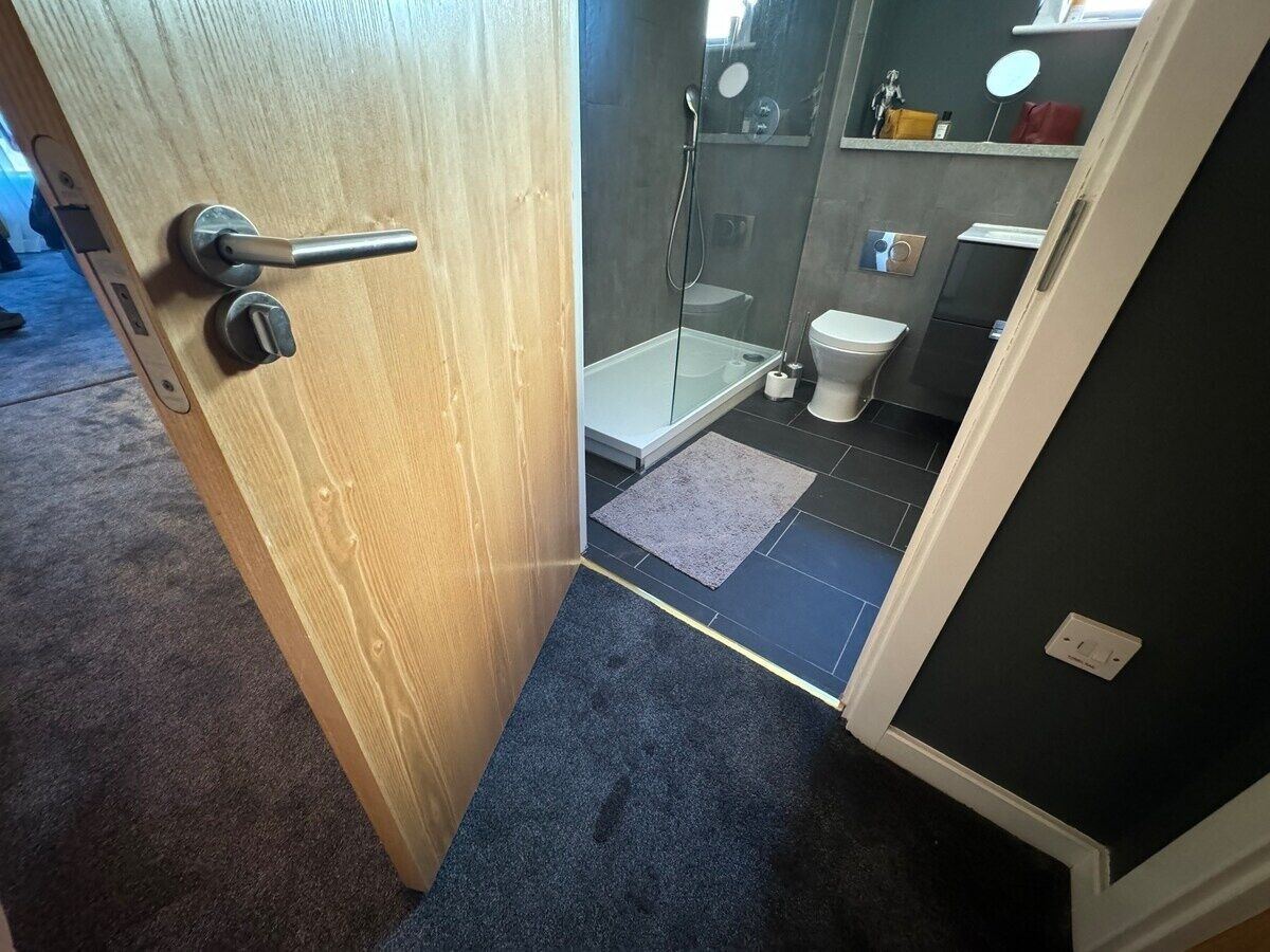 Une salle de bain avec douche, toilettes et lavabo.
