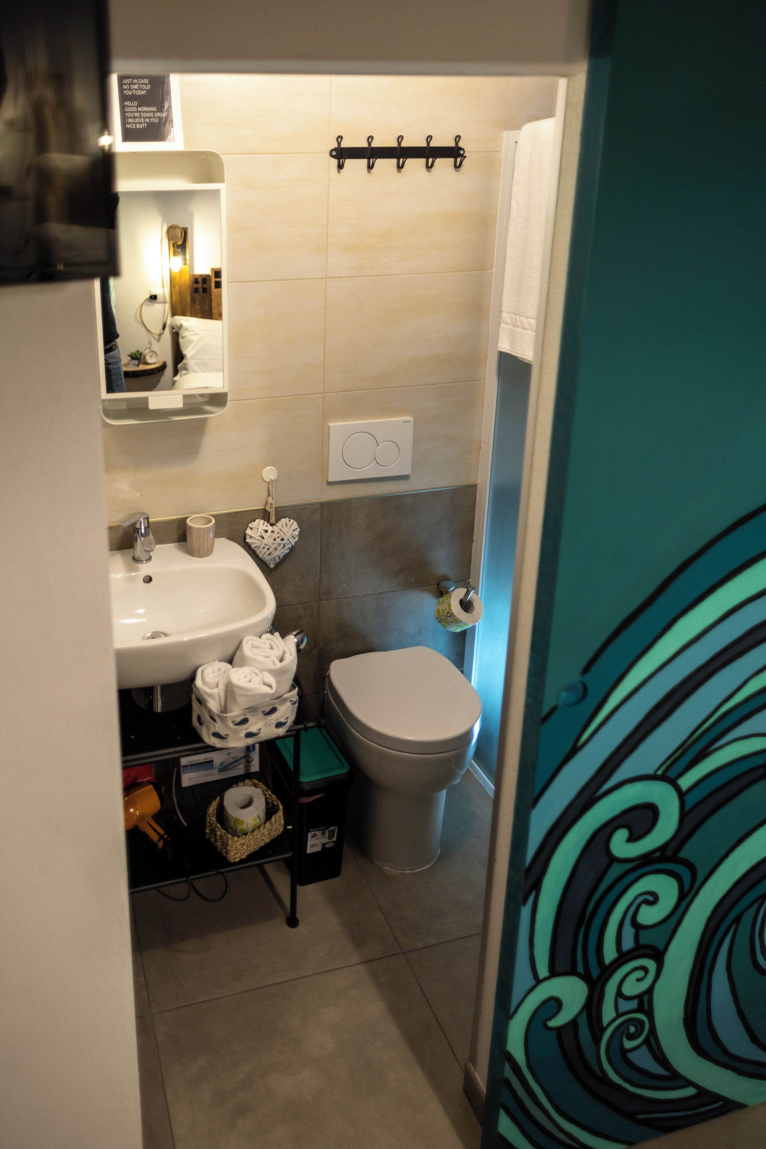 A bathroom with a sink, toilet, and towel rack.