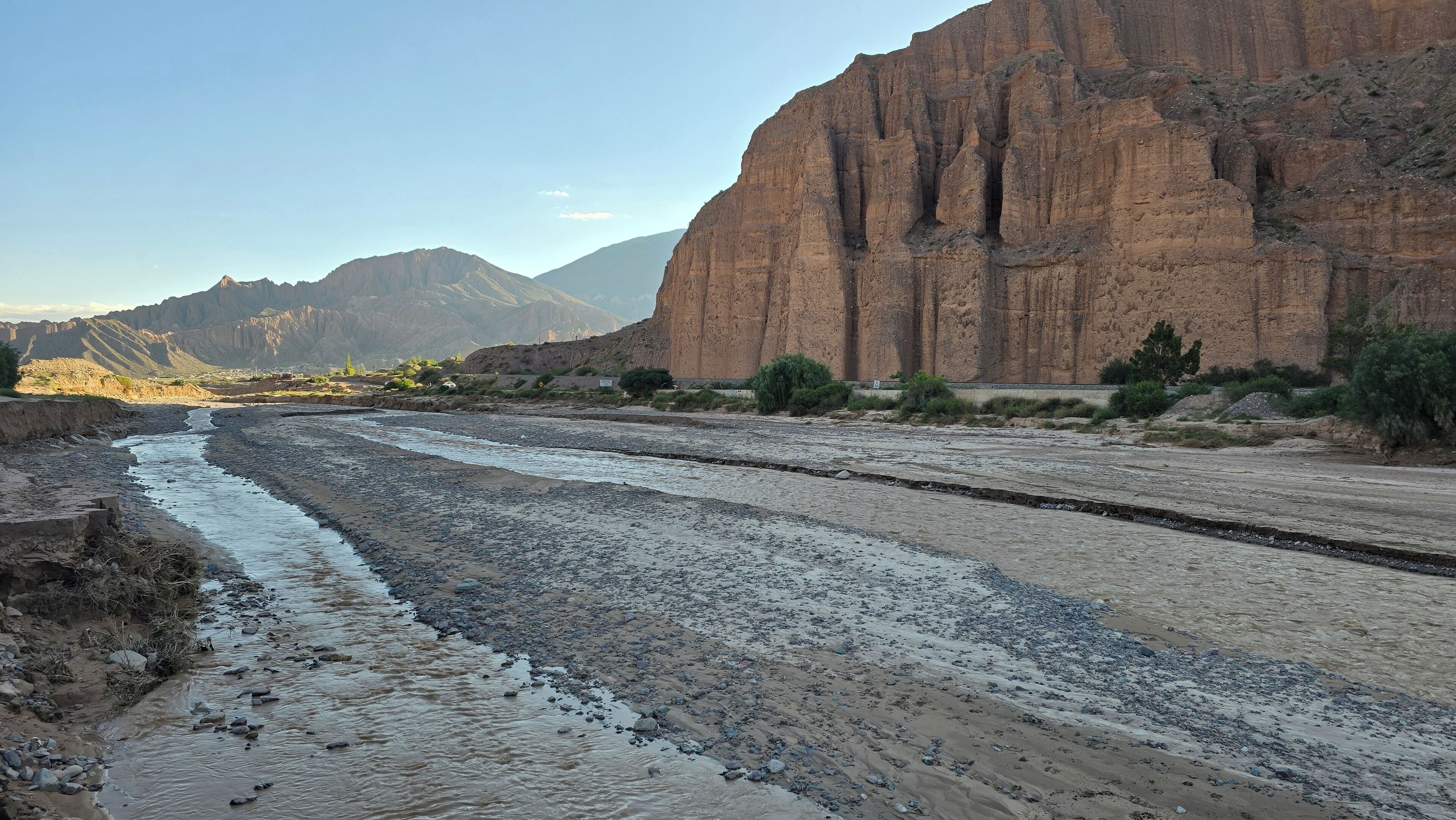 Un río que serpentea por un paisaje rocoso con montañas al fondo.