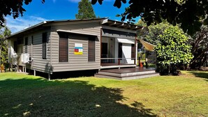 A single-story house with a front porch, a small deck, and a sign indicating holiday letting. - Rainbow North - Rainbow Beach (Rainbow Beach)