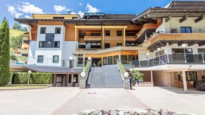 Un hotel de varios pisos con una escalera central, balcones y un cartel publicitario de las comodidades.