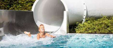 A water slide with a person at the bottom, surrounded by water.