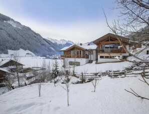 A wooden chalet with a balcony, surrounded by snow-covered mountains and a clear sky. - Family Ski Chalet With Views (Wald im Pinzgau)
