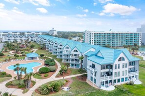 Een resort met meerdere gebouwen, een zwembad en verzorgde tuinen.