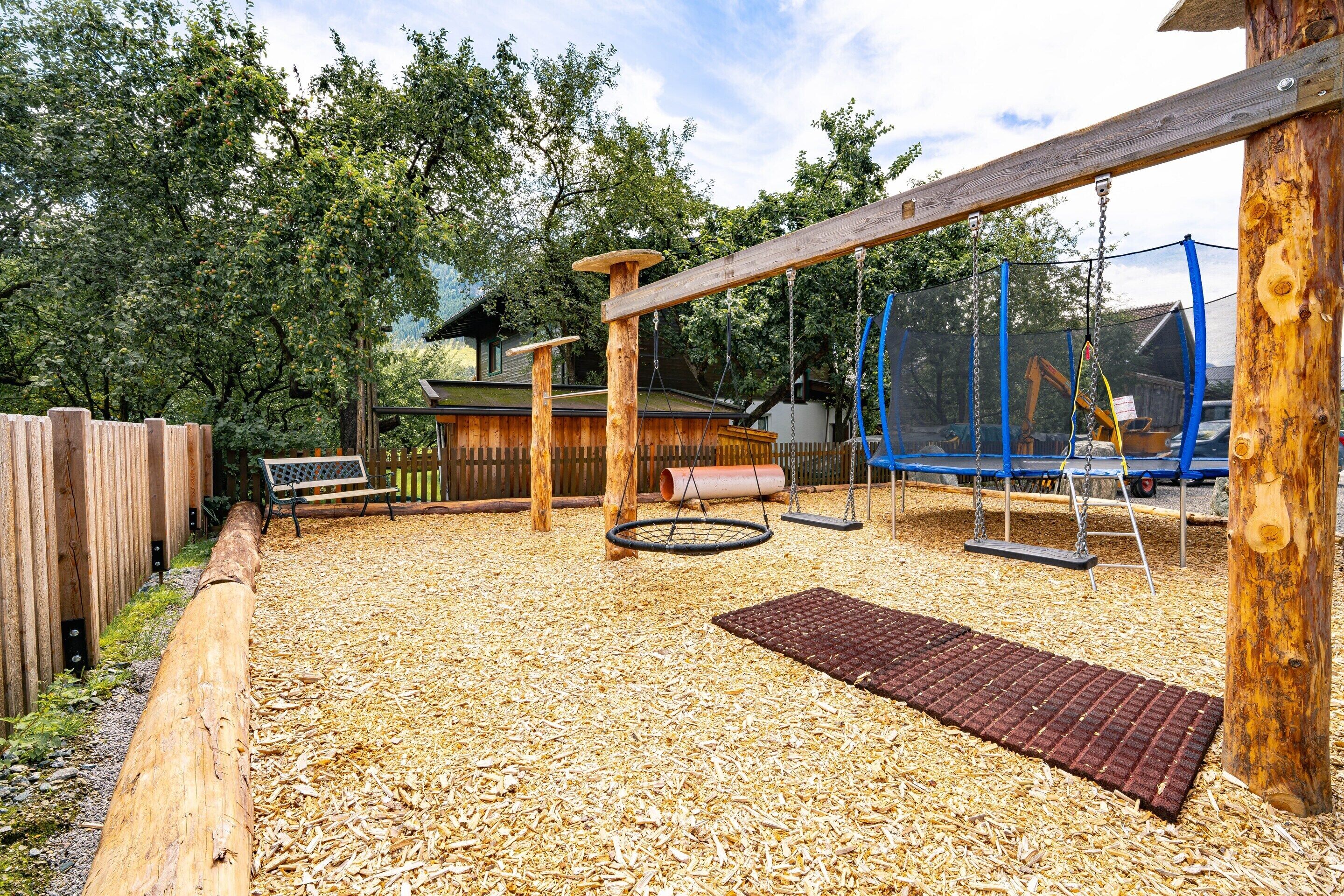 An outdoor playground with swings, a rope swing, and a tire swing.